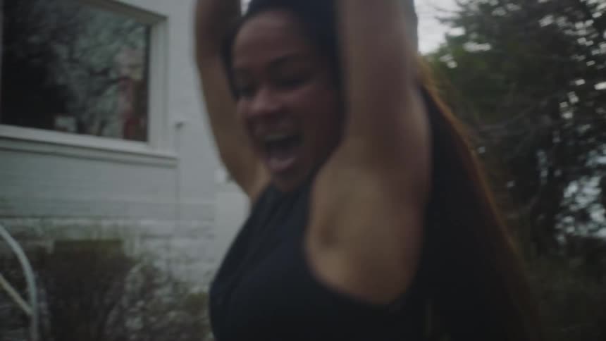 A mother swings her daughter around in the yard