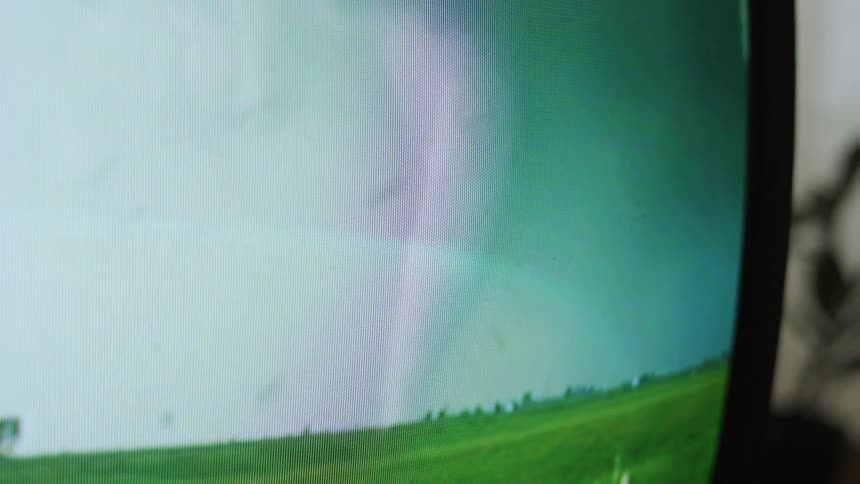 Close up of television screen showing a hurricane in the field