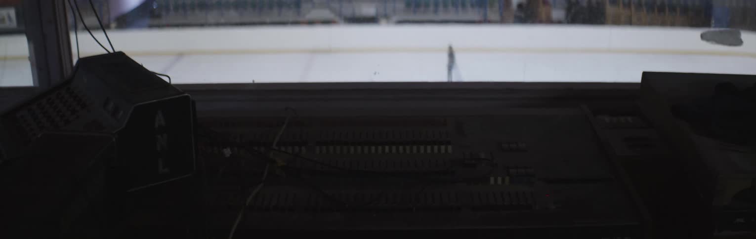 A girl ice skates in an empty rink