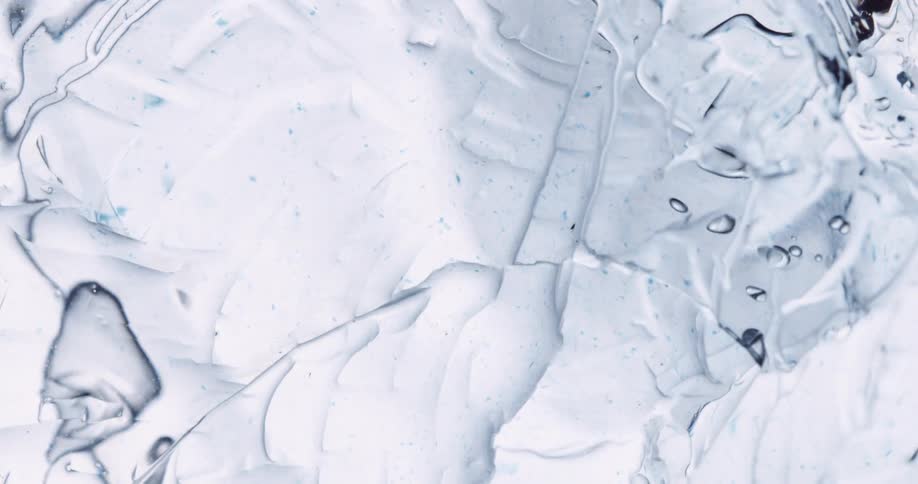Light shines on melting ice as it cracks and separates and bubbles move