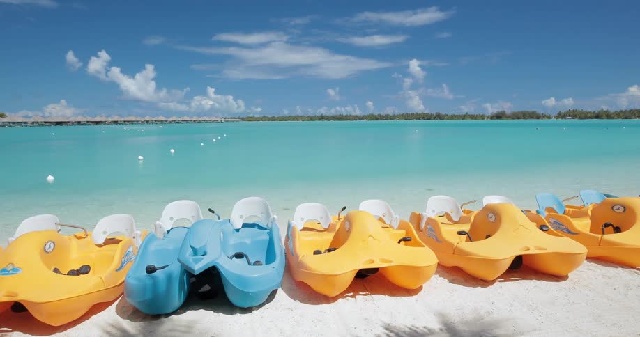 Small paddle boats and canoes line the shore