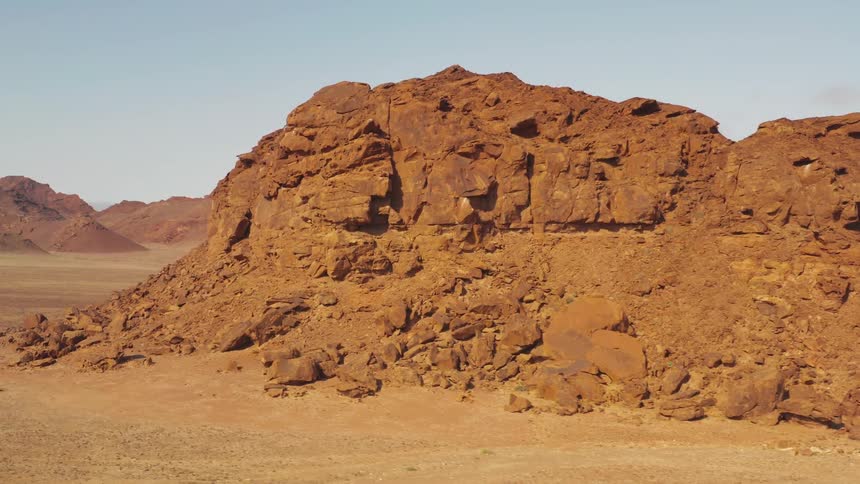 Crumbled rocks sit below a tall mesa in a canyon