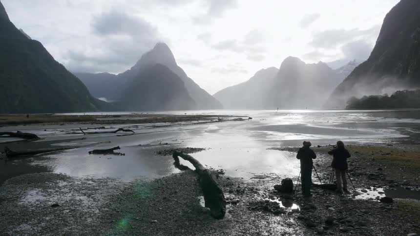 People are photographing a valley surrounded by mountains