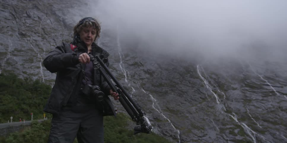 A woman packs up her tripod