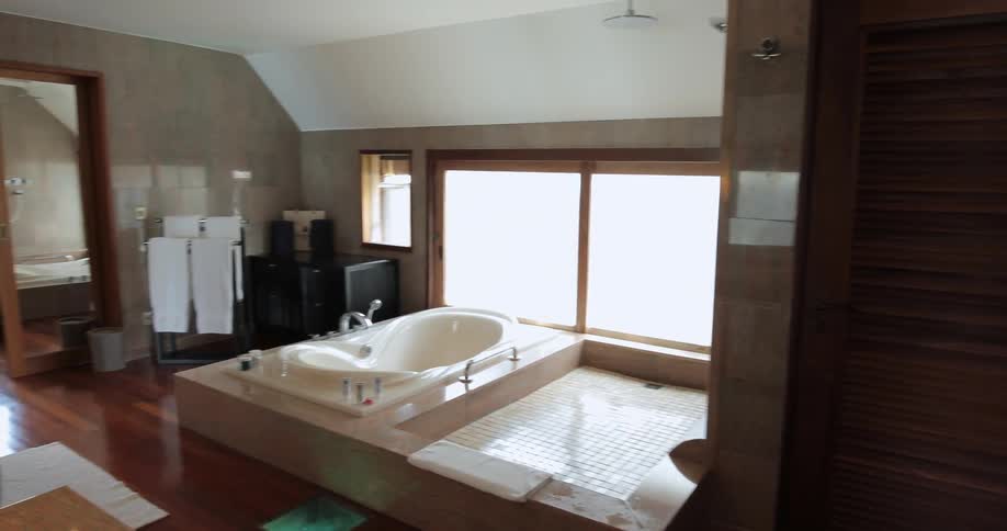 Walkthrough view of an apartment bathroom with a large garden tub