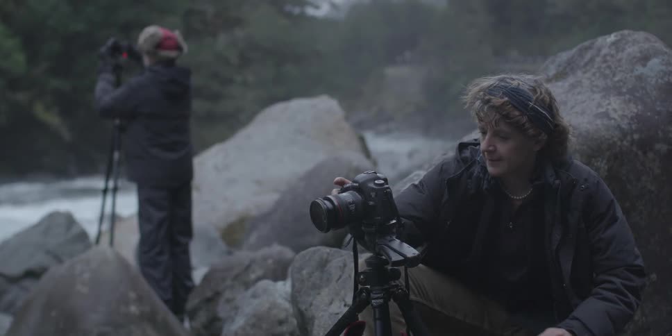 A man and woman adjusting their cameras