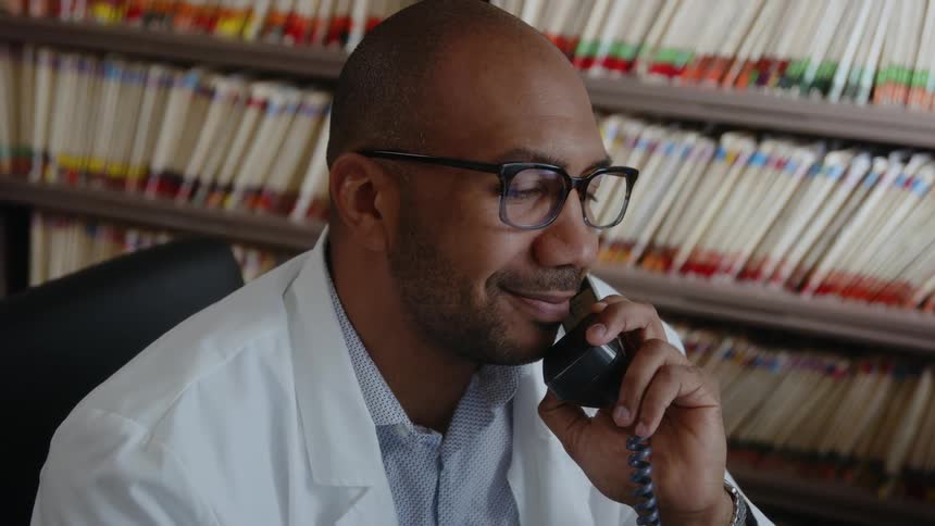 A man is smiling and talking on his phone