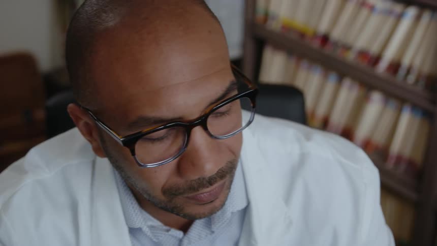 A doctor ponders then picks up a phone