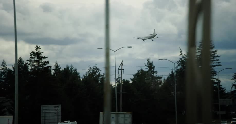 An airplane is taking off in a city during midday
