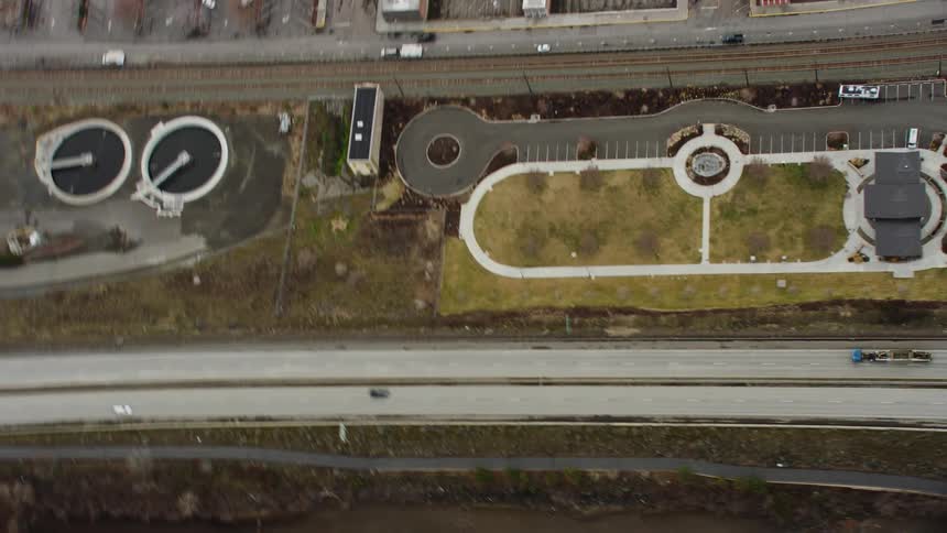 A birdseye view capturing a sprawling city with a lengthy bridge and houses located alongside it