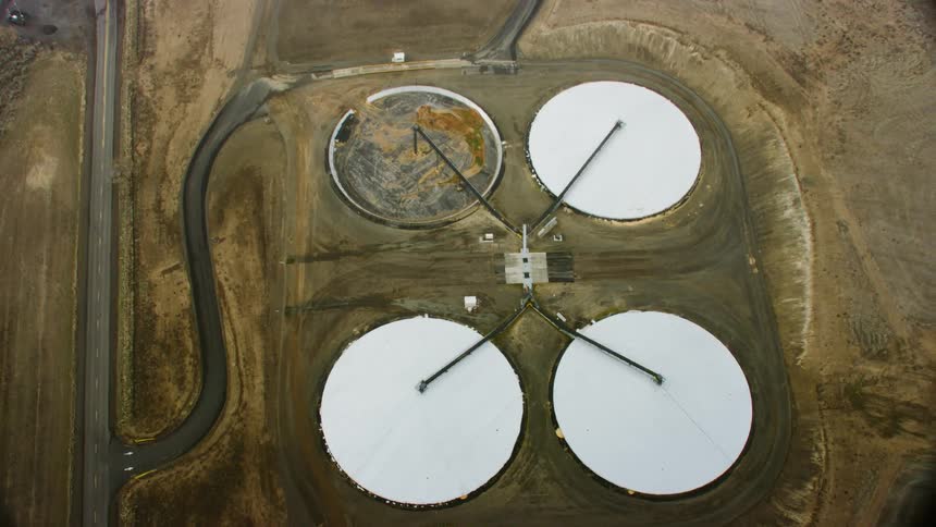 Four large circle shaped buildings sit together in a field