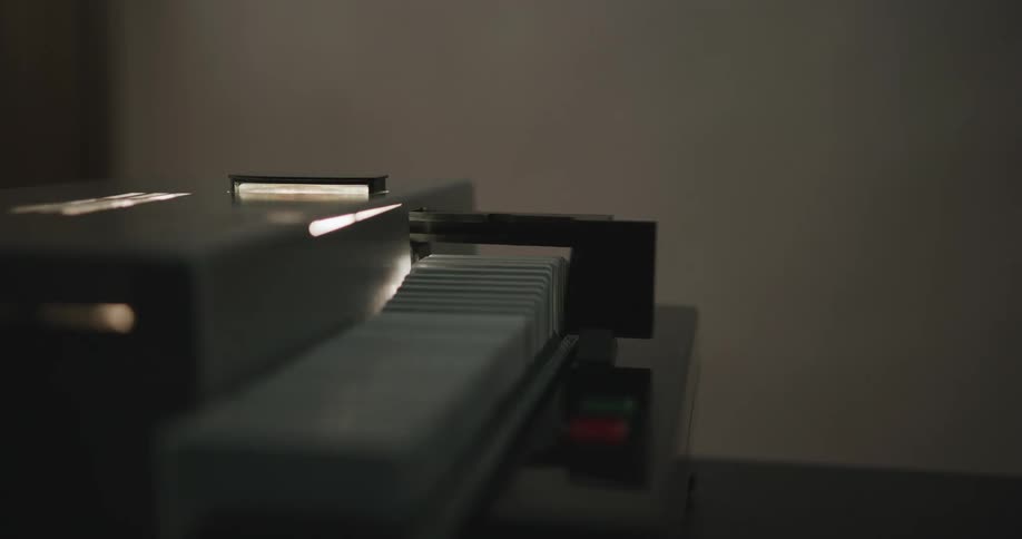 A slide machine projects blurry images in a darkened room