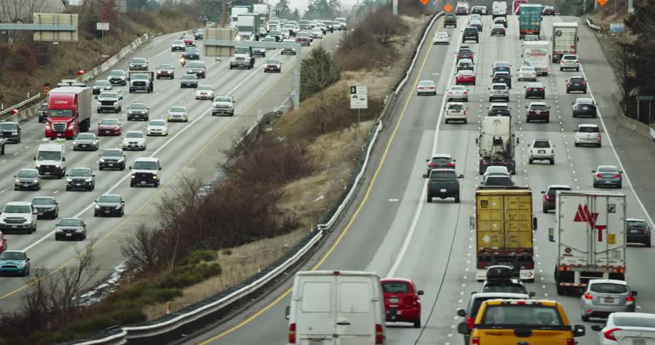 Heavy morning traffic on a foggy morning as city commuters navigate a large hill in a big city on the interstate highway