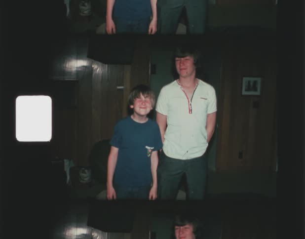 A young boy and a teen act silly while posing for the camera