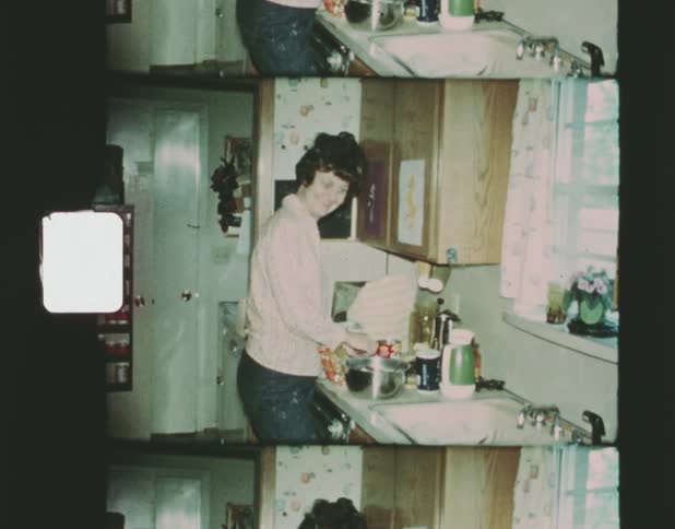 A woman standing in her kitchen preparing food next to a sink and bowl in front of her