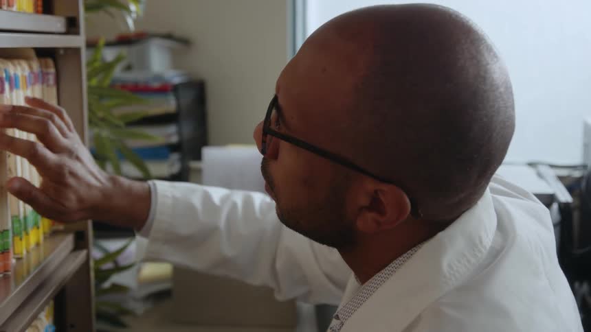 A man is looking at files in his office