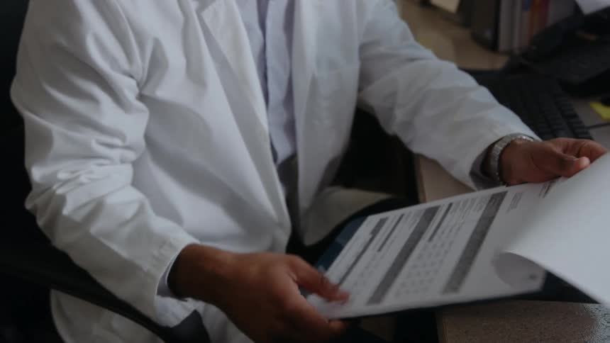 A doctor goes through a patients records in his office