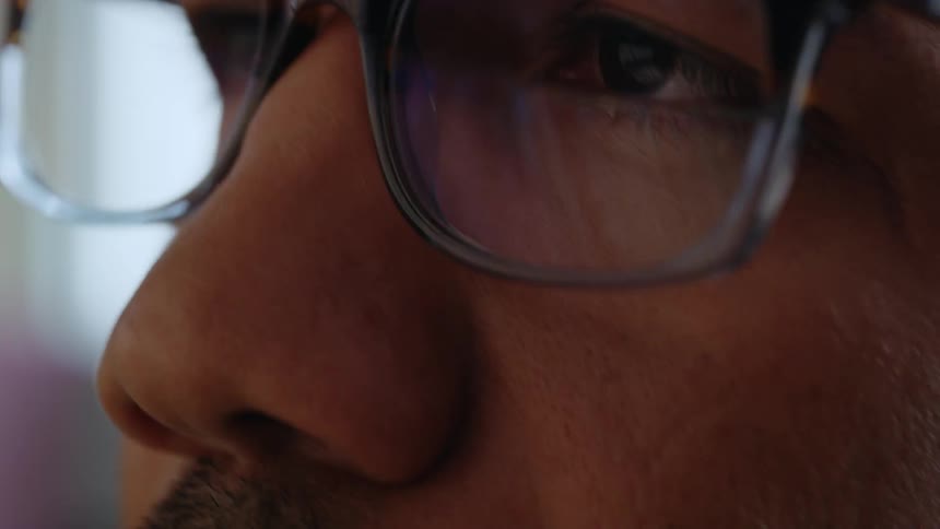 Close up view of a man wearing glasses indoors