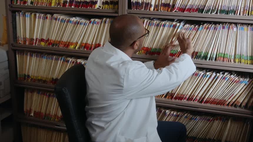 A man is grabbing files in his office