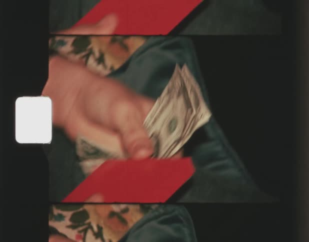 A hand putting some money in his red purse