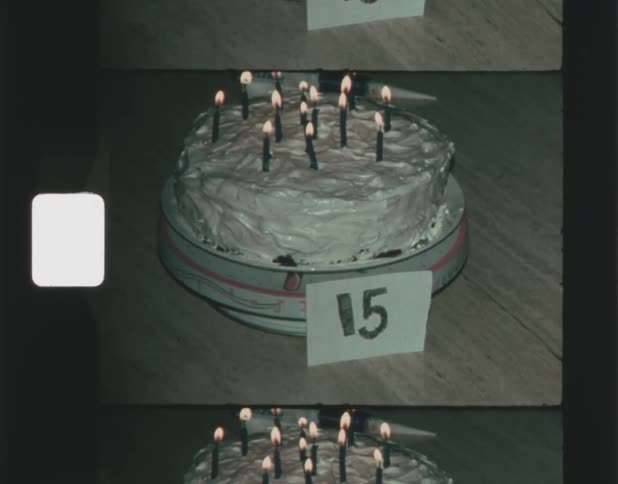 Close up of a birthday cake with a handwritten card in front of it caught on vintage film