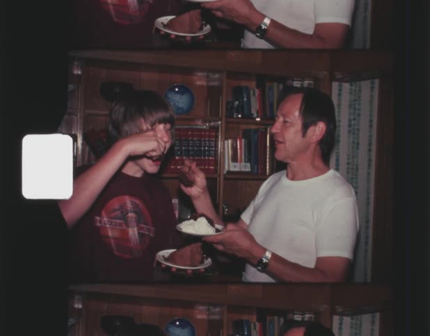 A father and son eating cake they have on their plates smiling and laughing