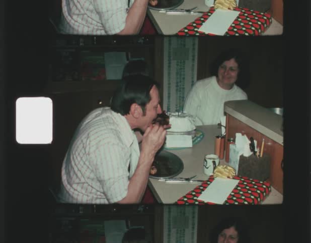 A father pretends to devour his piece of food to the amusement of his son