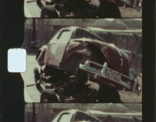 The exterior body of a car is lifted up and tilted off of its metal frame