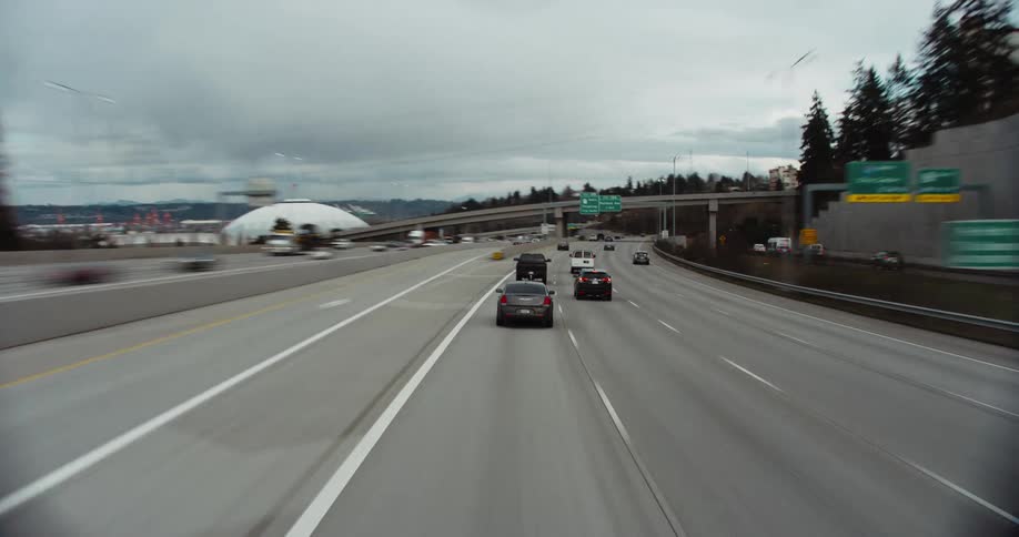 Hyper lapse following traffic on a four lane wide highway as cars move towards the city center