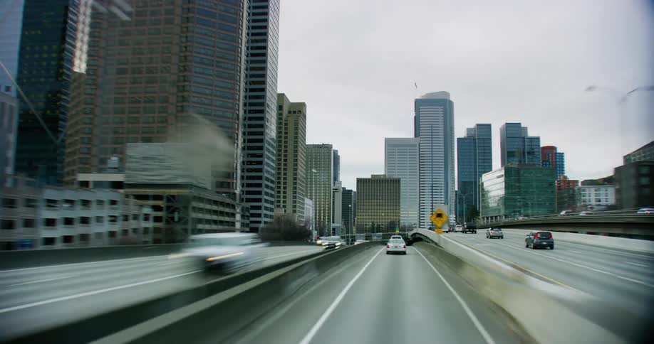 Hyper lapse shot traveling north through downtown Seattle as cars navigate the twists and turns and buildings rise high into the afternoon sky