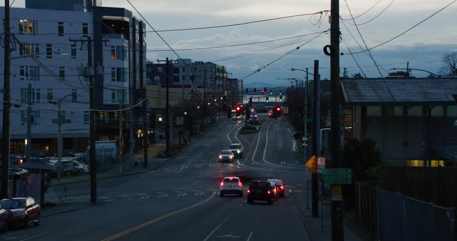 A city street with spedup traffic at an intersection at dusk