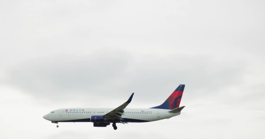 An airplane flies low as it comes in for a landing