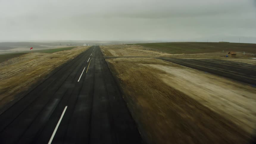 A view of a lonely highway that leads to a vast open field