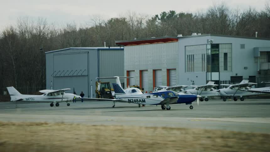 Singleengine aircraft piper taxiing in to small airport with other small planes around daytime