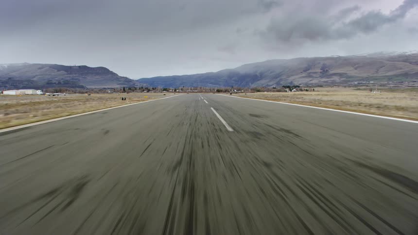 Plane lands on runway on a cloudy day
