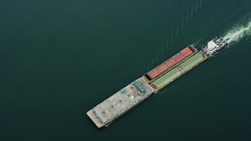 A cargo carrier boat crosses a stretch of water