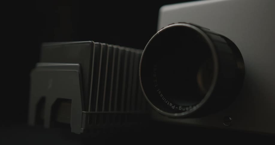 A projector lighting up and moving film forward close up