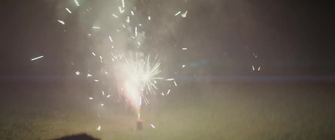 The firework shoots from the ground at night