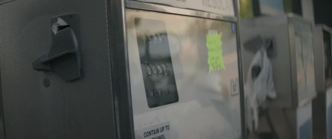 A person pumps gas at an old gas pump