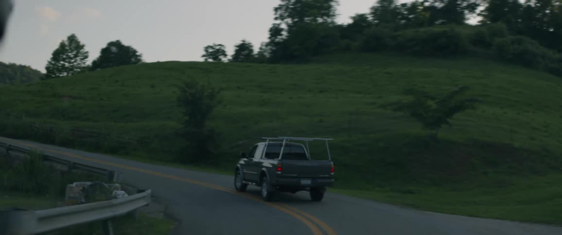 The truck travels down the winding road