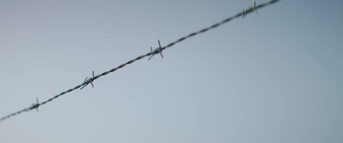 Barbed wire against blue sky
