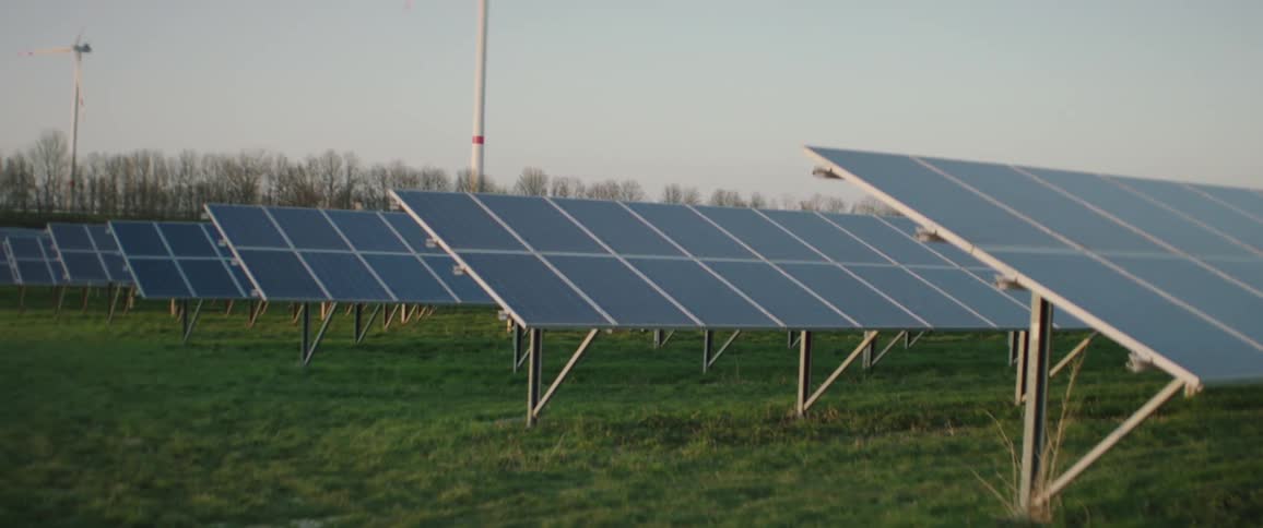 Solar panels and wind turbines in field