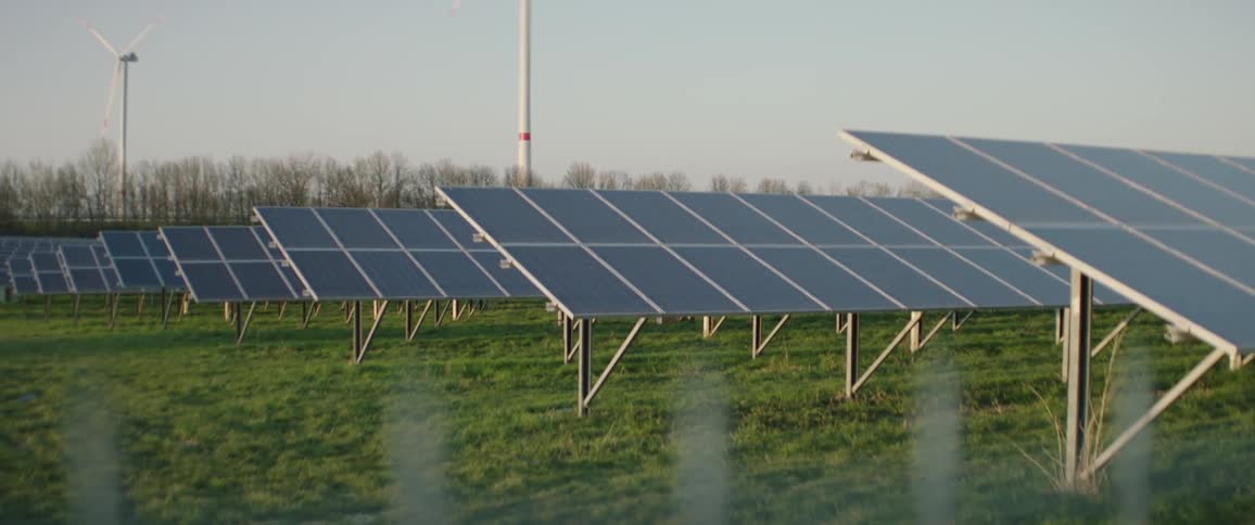 Large solar panels and wind turbines in field