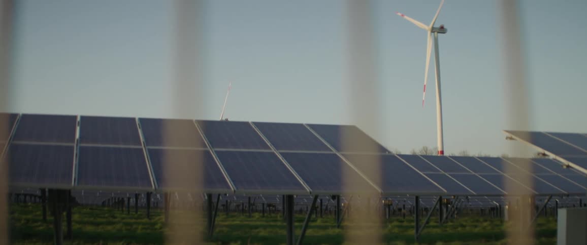 A wind turbine and solar panels fill the landscape
