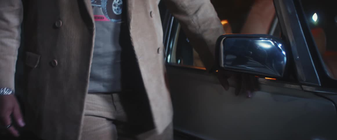 A man is walking near his car at night time