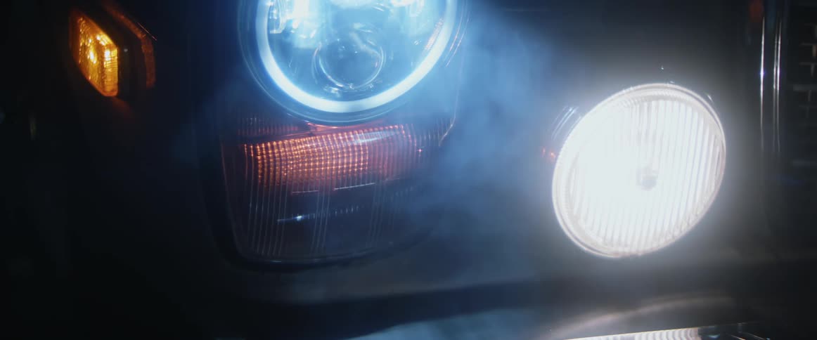 Smoke passes in front of bright car lights