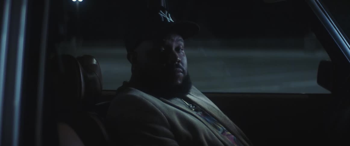 A man siting in his car looking at the camera and posing