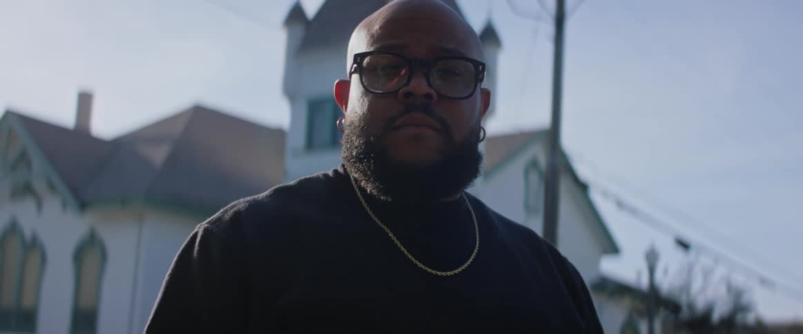Man stands and poses with church in the background