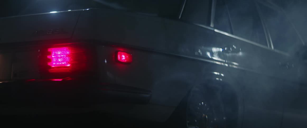 Close up of the brake lights of a parked old car turning on at night