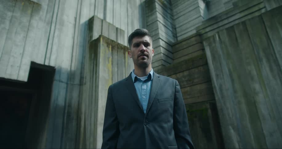 Man stands near interior corner of wooden multistoried building